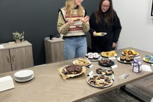 Lucy Bennett and Naomi Clarke at Blue Whale Media's MacMillan bake sale 2022