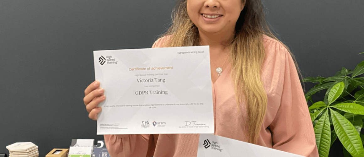 Victoria Tang holding a certificate for achievement in GDPR training and a certificate of achievement in Cyber Security