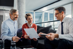 happy couple financial advisor going through plans during meeting scaled 1